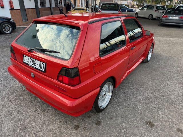 Volkswagen Golf G60 rojo, vista trasera lateral durante exposición en Rallye G60